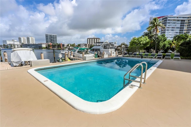 view of pool featuring a water view and a patio