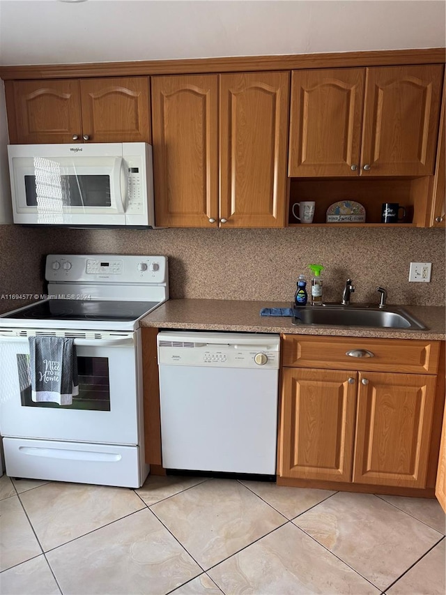 kitchen with decorative backsplash, white appliances, sink, and light tile patterned floors