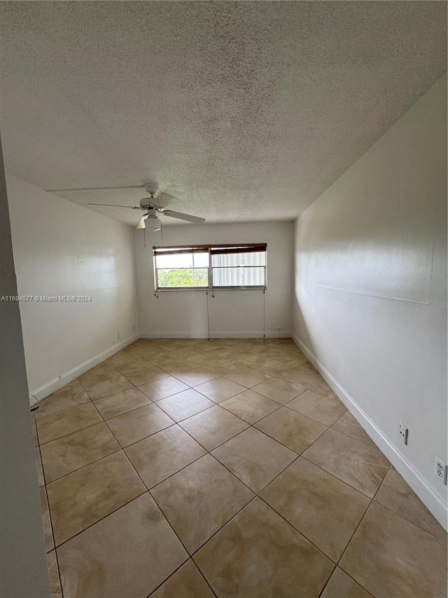 tiled spare room featuring ceiling fan and a textured ceiling