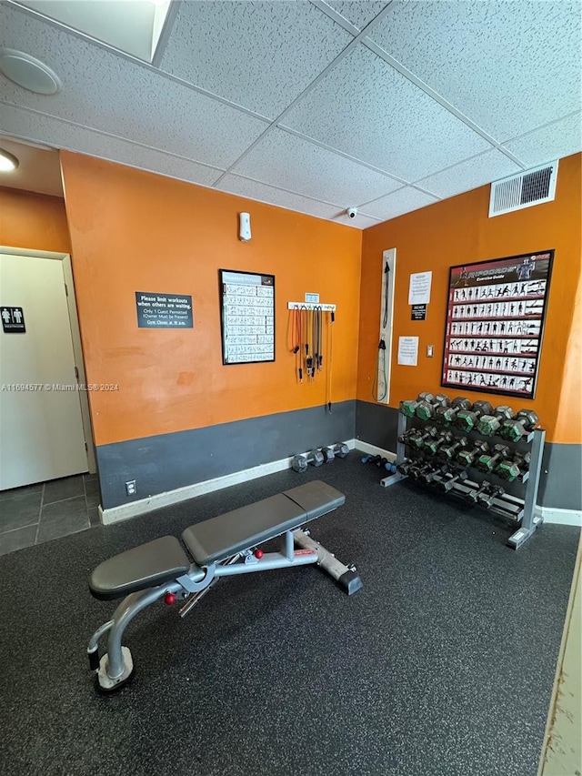 gym with a paneled ceiling