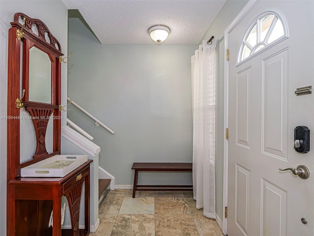 foyer entrance featuring a textured ceiling