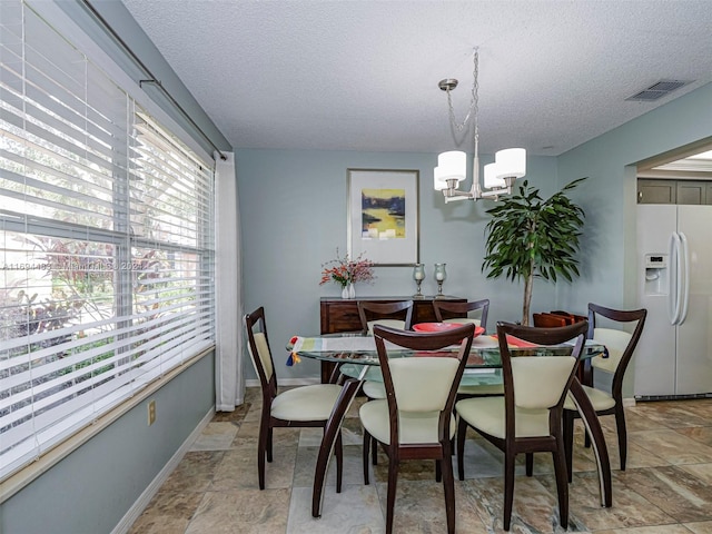 dining area with a notable chandelier and a textured ceiling