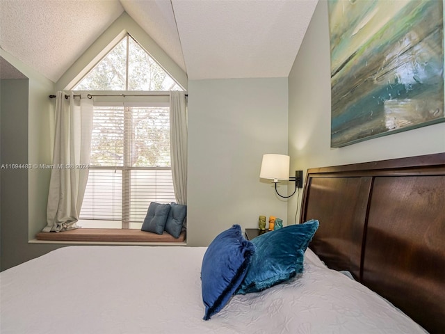 bedroom with lofted ceiling and a textured ceiling