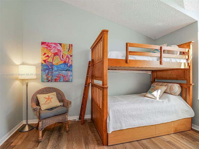 bedroom with hardwood / wood-style floors and a textured ceiling