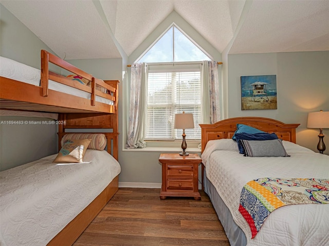 bedroom featuring dark hardwood / wood-style floors, lofted ceiling, and a textured ceiling