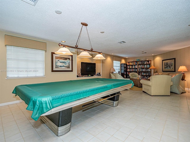 rec room with light tile patterned floors, a textured ceiling, a healthy amount of sunlight, and billiards