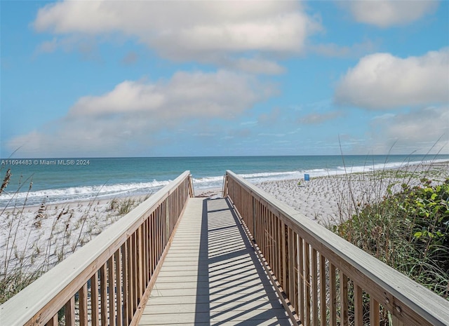 surrounding community featuring a water view and a beach view