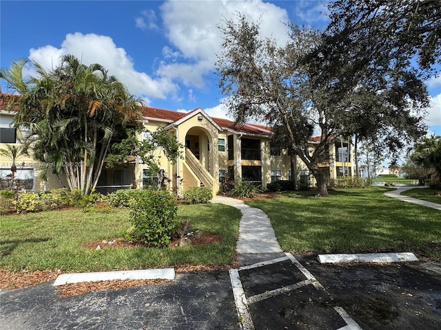 mediterranean / spanish house featuring a front lawn