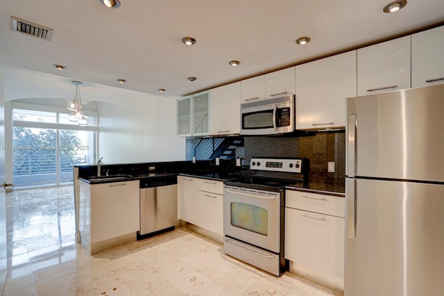 kitchen with kitchen peninsula, appliances with stainless steel finishes, and white cabinets