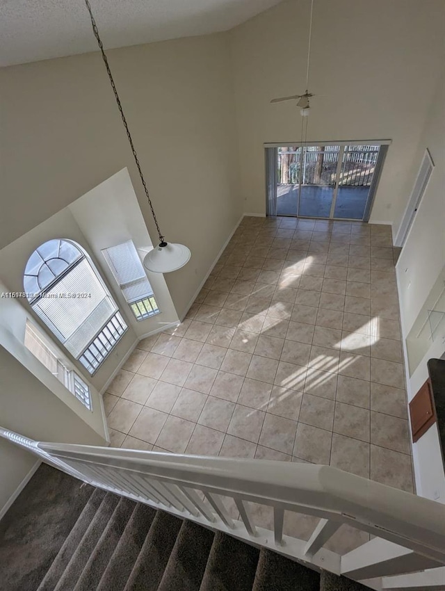 interior space with tile patterned floors, high vaulted ceiling, and ceiling fan