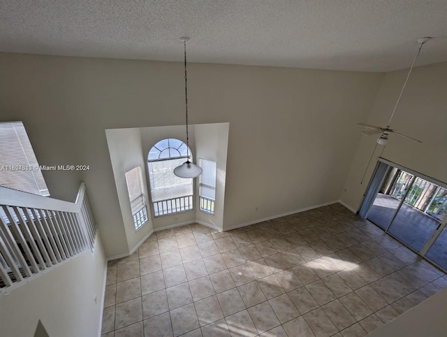 tiled foyer entrance featuring ceiling fan, high vaulted ceiling, and a textured ceiling