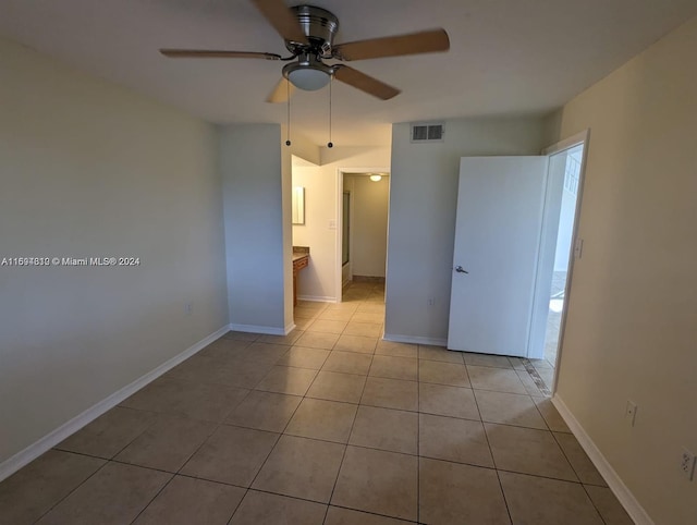 tiled spare room with ceiling fan