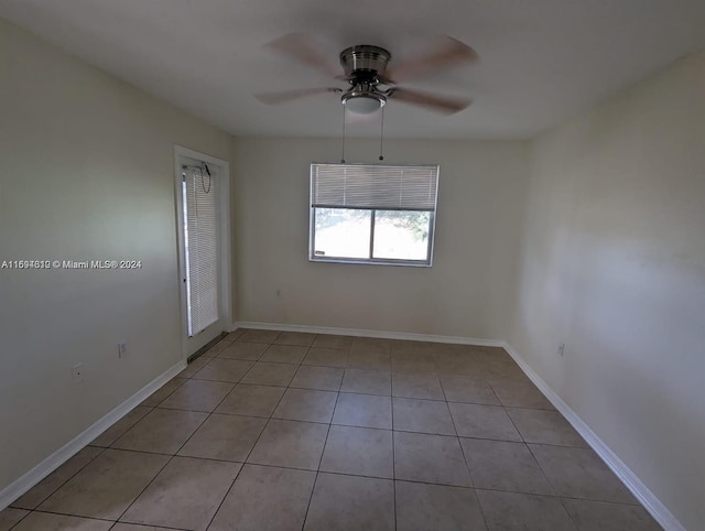 tiled spare room featuring ceiling fan