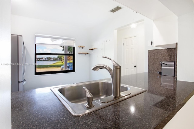 kitchen featuring stainless steel fridge and sink