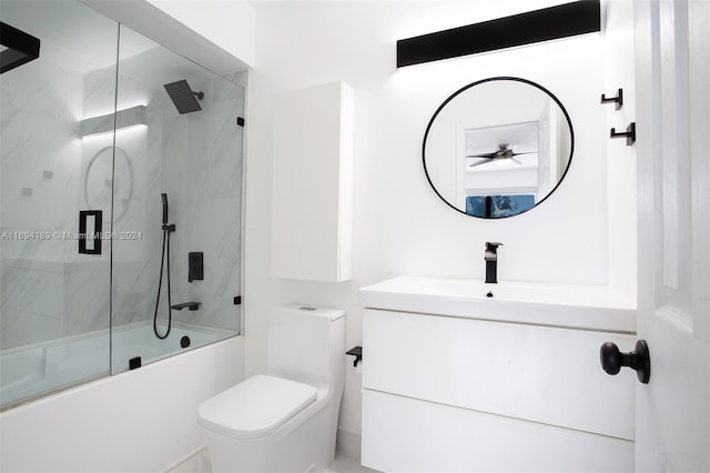 full bathroom featuring vanity, toilet, and shower / bath combination with glass door