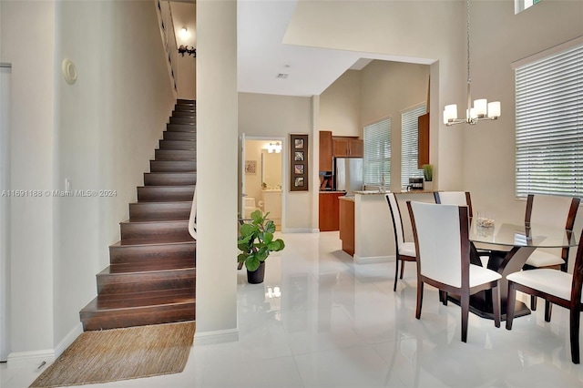 450 N Federal Hwy Unit 104N, Boynton Beach, FL 33435 - dining area with a towering ceiling, stairway, a chandelier, baseboards, and light tile patterned floors