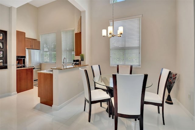 tiled dining room featuring plenty of natural light and a chandelier