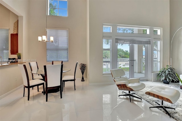 dining area featuring plenty of natural light, a high ceiling, and a notable chandelier