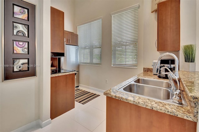 kitchen with light tile patterned flooring, stainless steel fridge, and sink