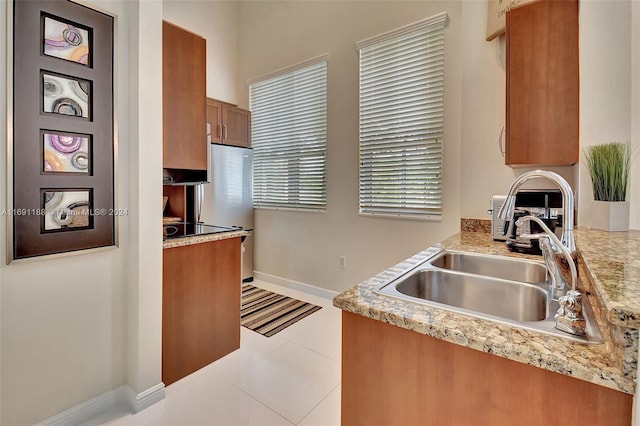 450 N Federal Hwy Unit 104N, Boynton Beach, FL 33435 - kitchen with a sink, brown cabinetry, light countertops, freestanding refrigerator, and baseboards