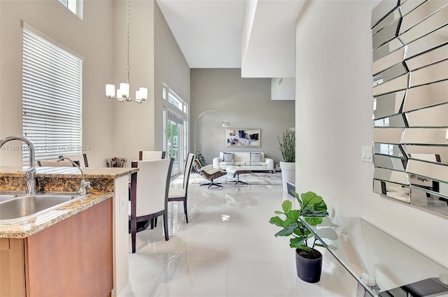 450 N Federal Hwy Unit 104N, Boynton Beach, FL 33435 - kitchen featuring a sink, brown cabinets, a chandelier, light tile patterned flooring, and light stone countertops