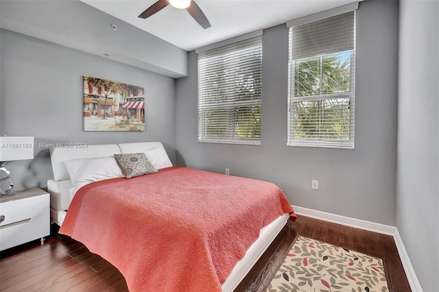 bedroom with multiple windows, ceiling fan, and dark hardwood / wood-style floors