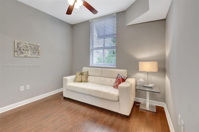 living area with ceiling fan and dark hardwood / wood-style floors