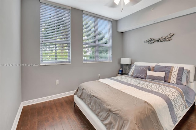 bedroom with multiple windows, ceiling fan, and dark hardwood / wood-style floors