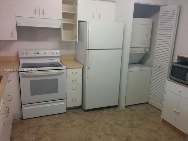 kitchen with stacked washer and dryer, white cabinets, and white appliances