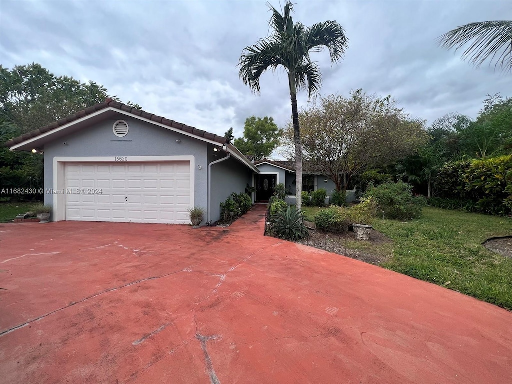 view of front of home featuring a garage and a front lawn