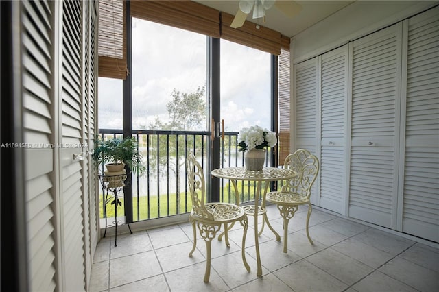 sunroom / solarium featuring a water view, ceiling fan, and a healthy amount of sunlight