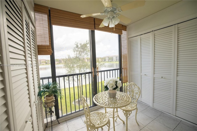 sunroom with a water view, ceiling fan, and a healthy amount of sunlight