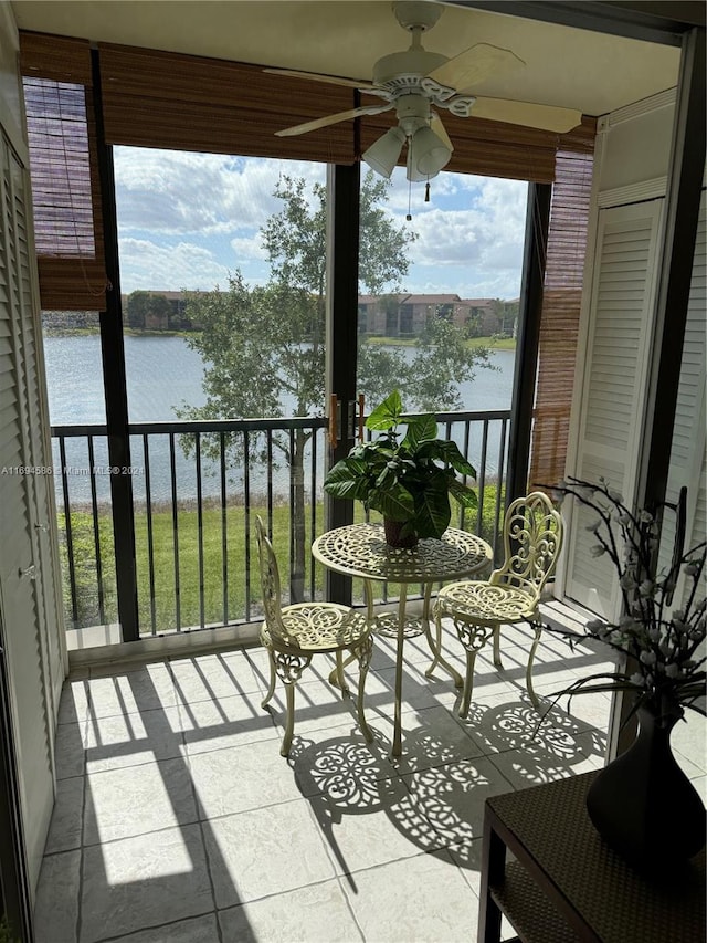 balcony with a water view and ceiling fan