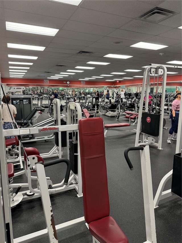 gym with a paneled ceiling