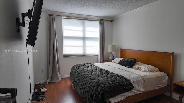 bedroom with dark hardwood / wood-style flooring, a textured ceiling, and ornamental molding