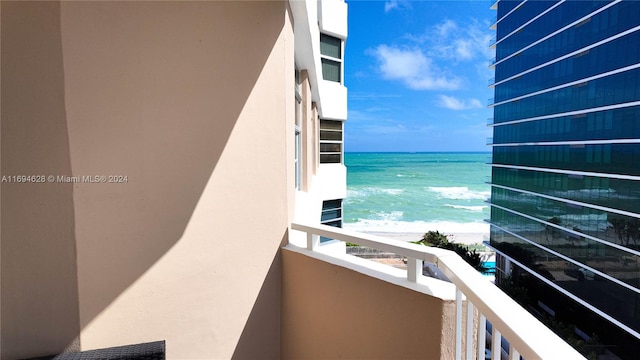 balcony featuring a water view and a beach view