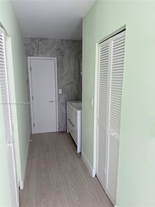 bathroom featuring vanity, toilet, tiled shower, tile walls, and wood-type flooring