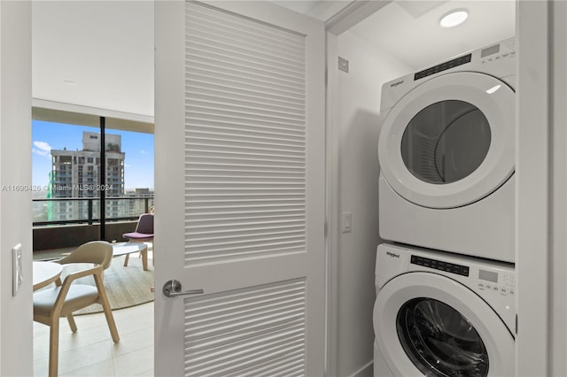 clothes washing area with stacked washer / dryer and light tile patterned floors