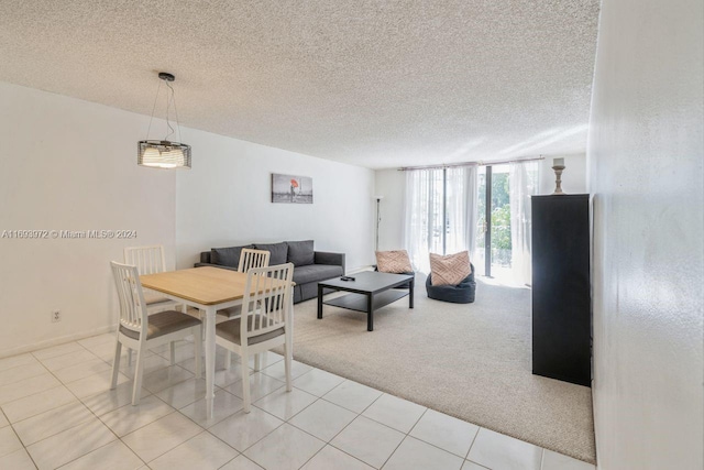 carpeted dining room with a textured ceiling