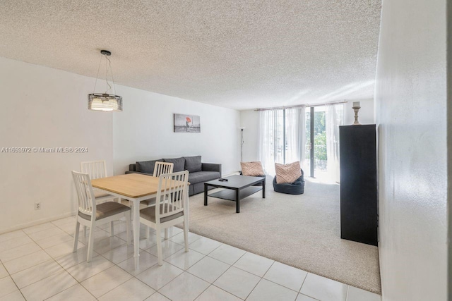 dining area featuring light carpet and a textured ceiling