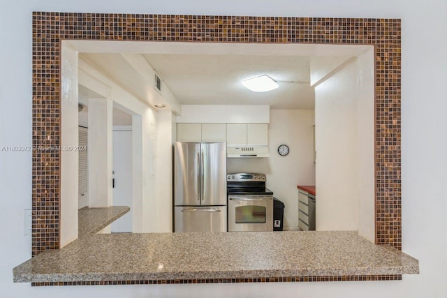 kitchen featuring white cabinets, ventilation hood, light stone countertops, a textured ceiling, and appliances with stainless steel finishes