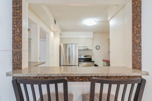 kitchen with kitchen peninsula, white cabinetry, ventilation hood, and appliances with stainless steel finishes