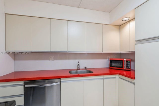 kitchen featuring appliances with stainless steel finishes, white cabinetry, and sink