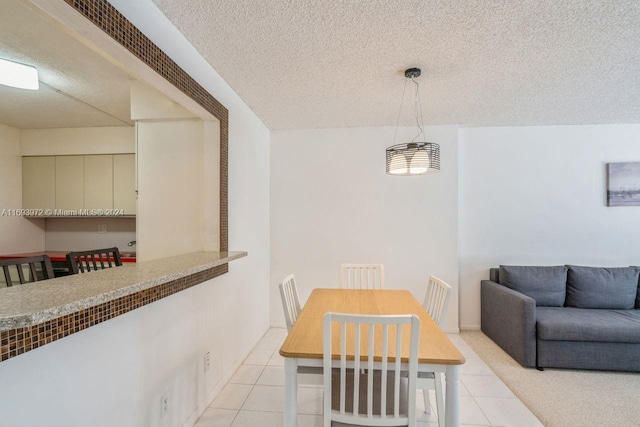 dining area featuring light tile patterned floors and a textured ceiling