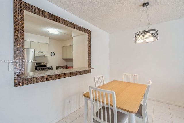 tiled dining area featuring a textured ceiling