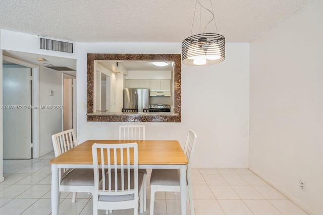 dining room with light tile patterned flooring and a textured ceiling