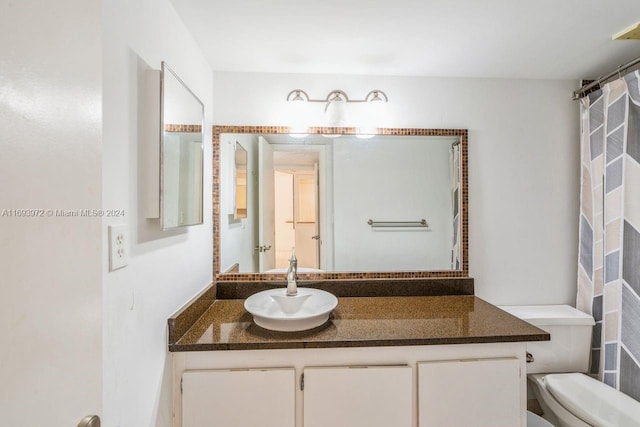 bathroom featuring vanity, toilet, and curtained shower