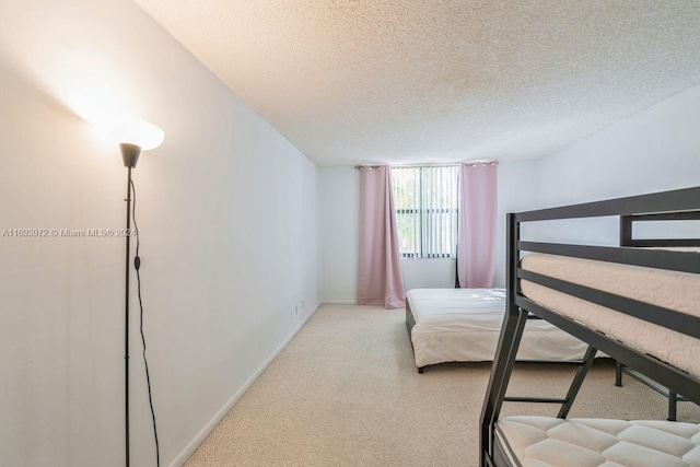 bedroom with light carpet and a textured ceiling