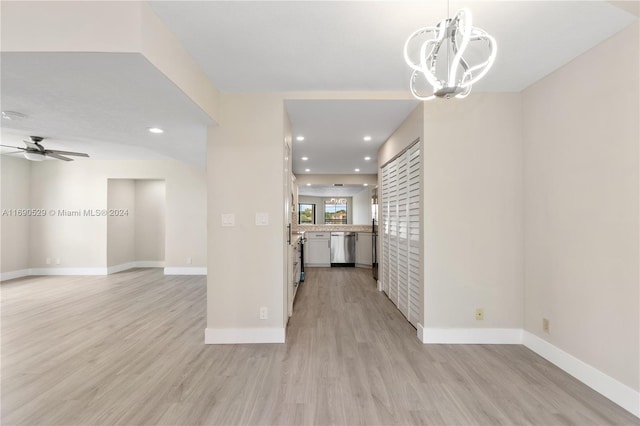 interior space with ceiling fan with notable chandelier and light hardwood / wood-style floors