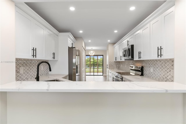 kitchen featuring white cabinetry, kitchen peninsula, and appliances with stainless steel finishes